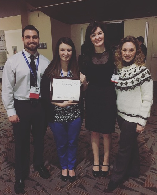 Pharmacy students and teacher standing with award