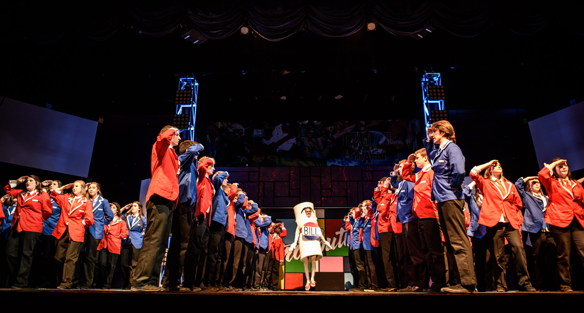 Students in costume on stage saluting