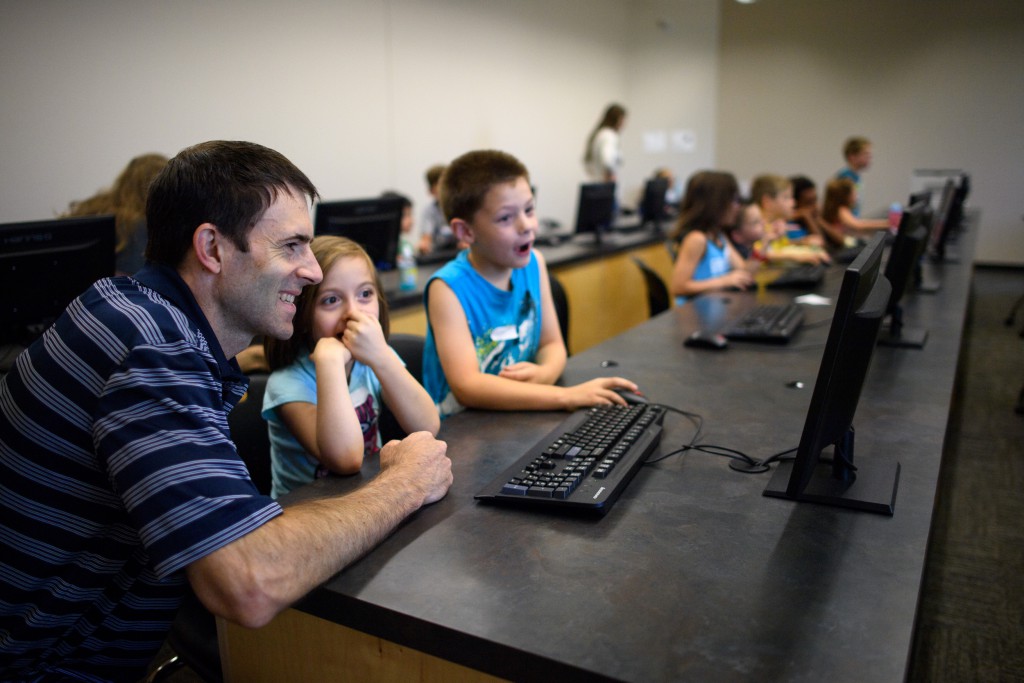 Teacher working with kids on a computer