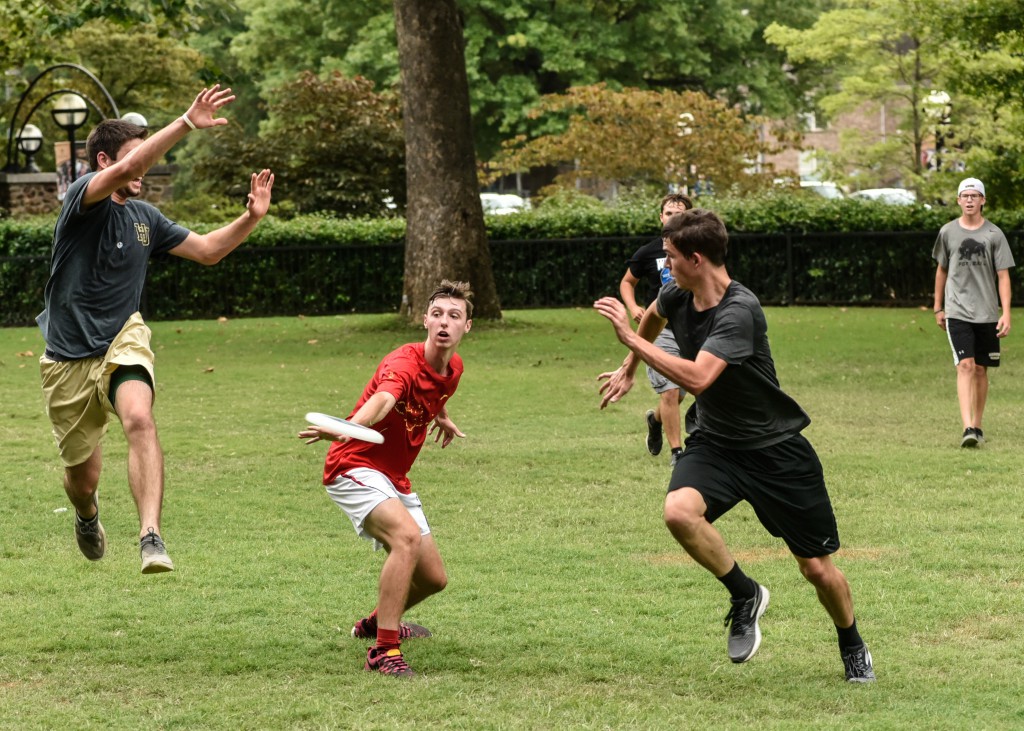  Students attending a session of the University's Honors Symposium play a game of Frisbee during free time.