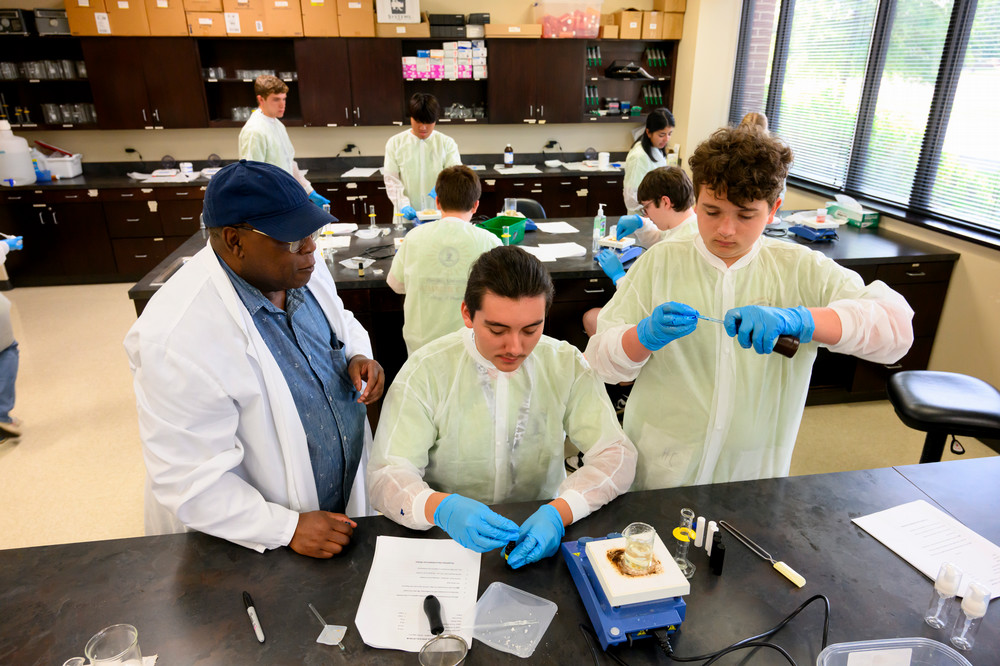 Dr. Yeboah coaches two pharmacy camp students through an experiment