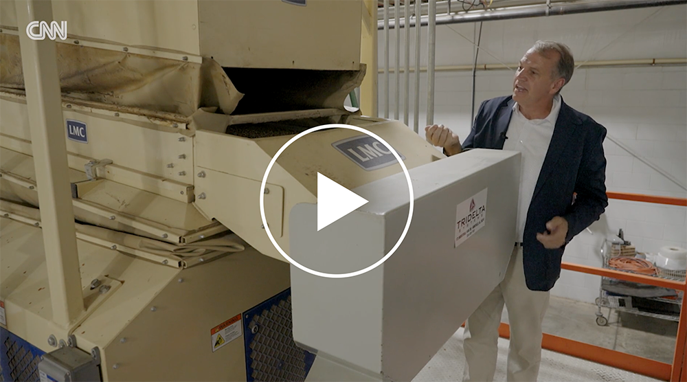 Mark Moore poses with and explains food processing machine