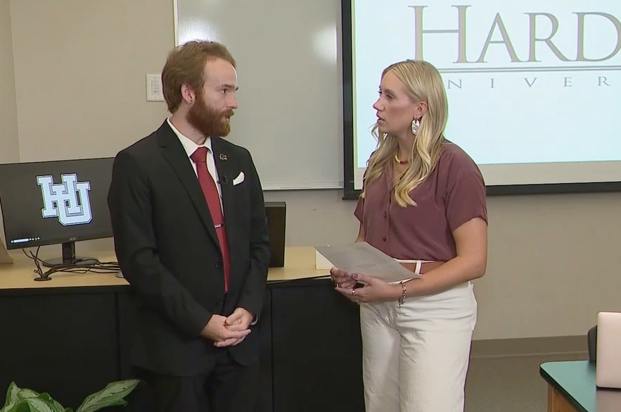 white male in a suite speaking to a formally dressed white female